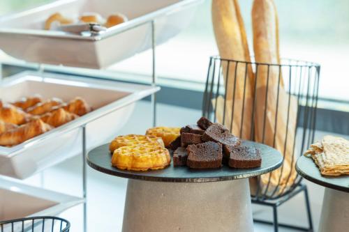 a plate of donuts and other pastries and bread at Novotel Suites Nancy Centre in Nancy