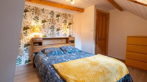 a bedroom with a bed with a blue comforter at Gîte La Proue du Serre 4/5 personnes in Sainte-Énimie