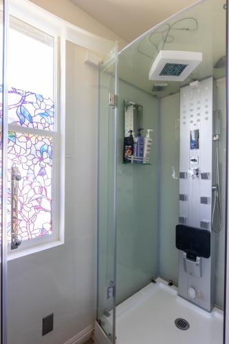 a bathroom with a shower with a window and a glass door at Overlooking Marina del Rey sailboats, is Green Ginger Playa Del Rey on the bluff, in Los Angeles