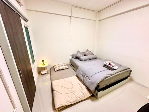 a small bedroom with a bed and a window at อมรรัตน์Room in Pathum Thani