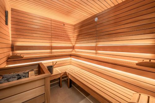 a wooden sauna with a bench and a table in it at Boutique Hotel Aichinger in Nussdorf am Attersee