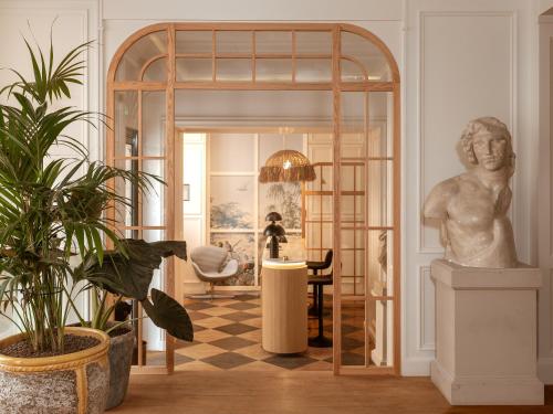 a room with a statue and a table with a chair at Hôtel Zélie in Paris