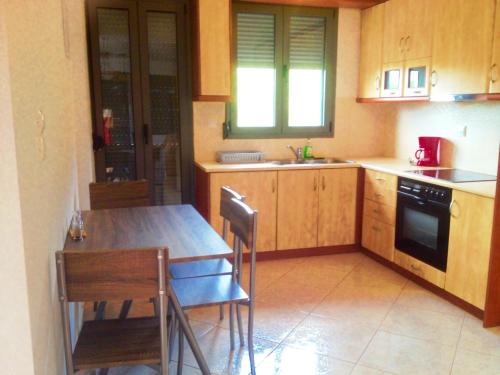a kitchen with wooden cabinets and a table and chairs at Nitelli's Houses in Skála Néon Kydonión