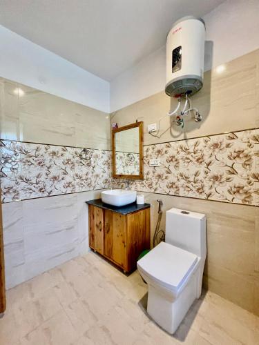 a bathroom with a toilet and a sink at The Highgrove House, Manali in Haripūr