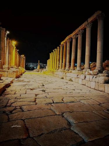a row of columns on a building at night at شاليه بانا جرش in Jerash