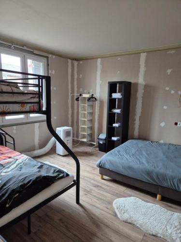 une chambre avec deux lits superposés et un mur recouvert de peinture dans l'établissement Le Cirque 03, à Dompierre-sur-Besbre
