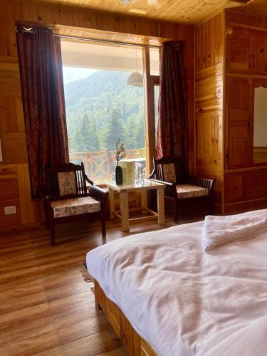 a bedroom with a bed and a large window at The Highgrove House, Manali in Haripūr