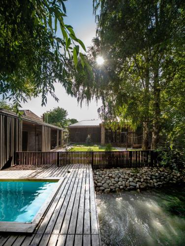 a backyard with a swimming pool and a wooden deck at Green Villa Near Bishkek in Këk-Dzhar