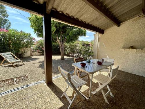 une table blanche et des chaises sur une terrasse dans l'établissement Maison 5 couchages avec terrasse, climatisation, proche plage et commerces à Saint-Cyprien - FR-1-225D-213, à Saint-Cyprien
