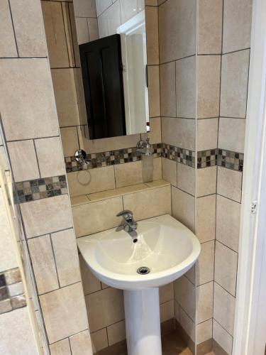 a bathroom with a sink and a mirror at La Gaffe - Bed and Breakfast in London