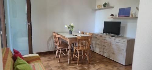 a living room with a table and chairs and a television at Teresa in Tortolì