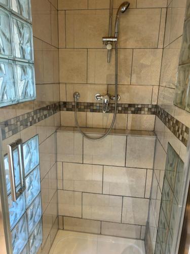 a shower with a hose in a bathroom at La Gaffe - Bed and Breakfast in London