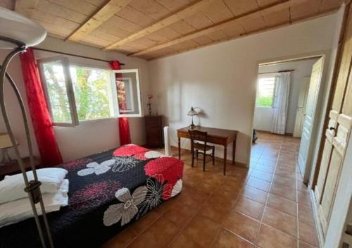 a bedroom with a bed and a desk in a room at Villa plain pied in Sommières