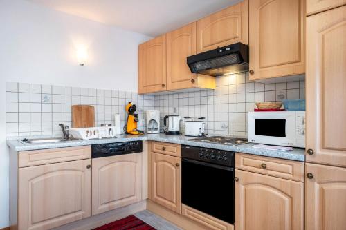 a kitchen with wooden cabinets and a stove top oven at Haus Marianne Duffner in Schonach