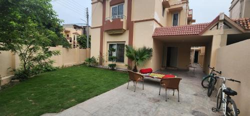a small yard with a table and chairs in a backyard at Haven Lodge - 4BR Luxurious Spanish Villa in Lahore in Lahore