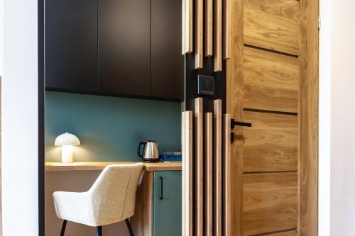 a kitchen with a wooden door and a chair at Willa Amelia in Solina