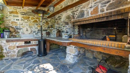 a stone fireplace with a bench in a stone building at Μountain Whispers in Mouresi