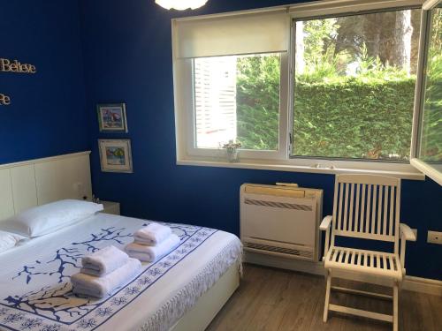 a bedroom with a bed and a chair and a window at Pines House in Draç