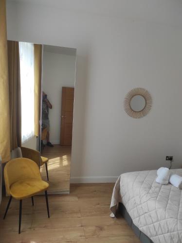 a bedroom with a bed and a chair and a mirror at Cosy Private Home in London with Garden in London