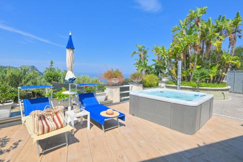 een patio met een hot tub en 2 stoelen bij Villino La Canfora in Ischia