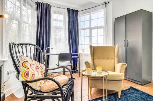 a living room with two chairs and a table at 8 Private Rooms with own kitchen & bathroom, Parking, 30min to Wembley Stadium, sleeps 16 to 20 people in Colindale