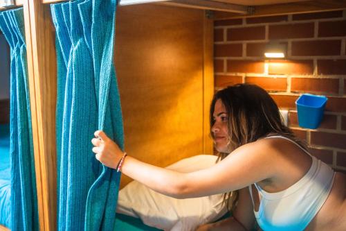 a woman is looking out of a window at Sagres Sun Stay - Surf Camp & Hostel in Sagres