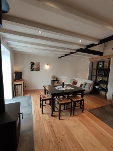 a living room with a black table and chairs at Maison cosy au cœur du Marais Poitevin in Benet