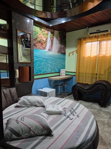 a bedroom with a large bed with a painting on the wall at papillon hotel in São Paulo