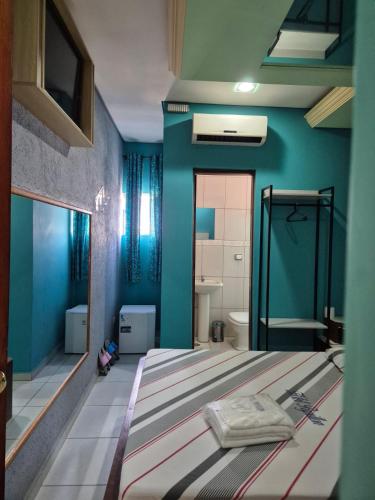 a bedroom with a bed and a blue wall at papillon hotel in São Paulo