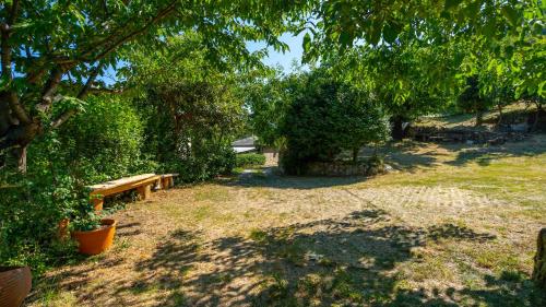 a park with a bench and trees and grass at Μountain Whispers in Mouresi