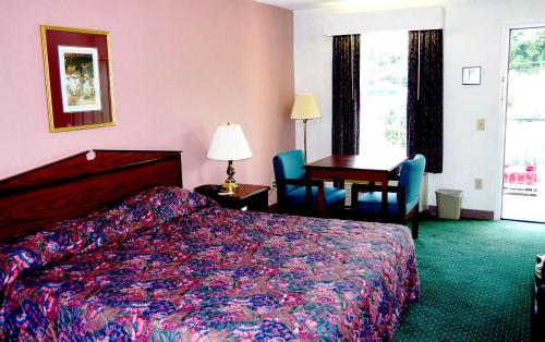 a hotel room with a bed and a desk at American Motel - Lenoir in Lenoir