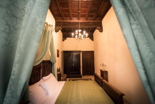a bedroom with a bed and a chandelier at All'ombra della Torre only Rooms in Siena