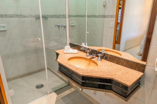 a bathroom with a sink and a shower at Hotel Nacional Inn Campos do Jordão in Campos do Jordão