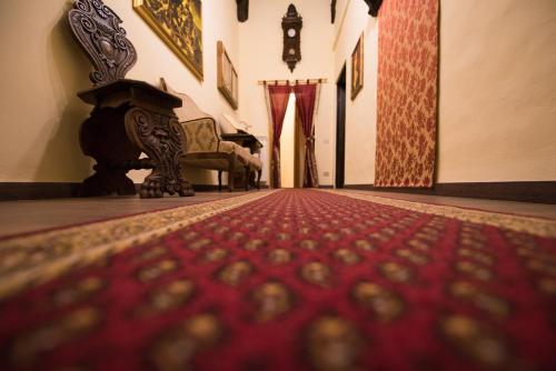 a hallway with a couch and a red carpet at All'ombra della Torre only Rooms in Siena