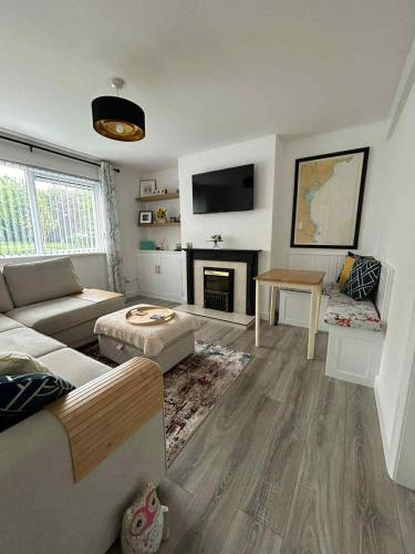 a living room with a couch and a fireplace at The Wee Flat - Donaghadee in Donaghadee