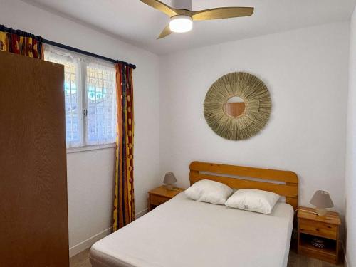 une chambre avec un lit et un ventilateur de plafond dans l'établissement Appartement 2 pièces/cabine, près de la plage avec loggia - Parking privé, TV, lave-linge & lave-vaisselle - FR-1-225-85, à Argelès-sur-Mer