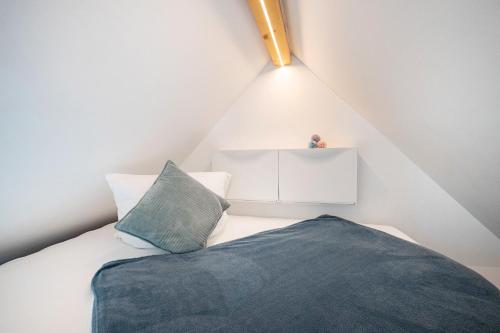 a small attic bedroom with a bed and a pillow at Tinyhaus Supreme für 1-4 Personen in Fuchsmühl