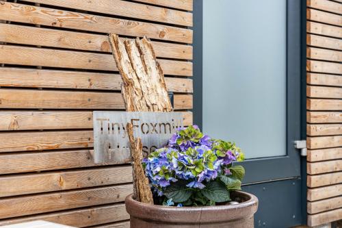 a planter with purple flowers in front of a door at Tinyhaus Supreme für 1-4 Personen in Fuchsmühl