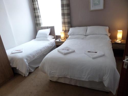 two beds in a hotel room with towels on them at Nathans in Blackpool