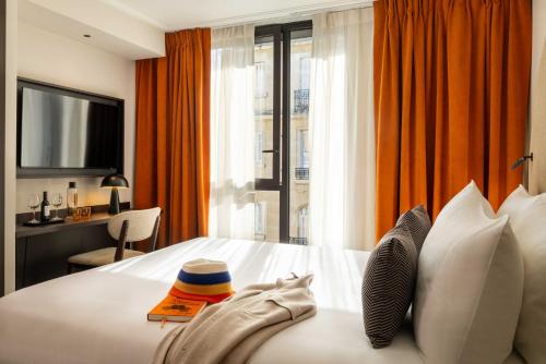 a hotel room with a large bed with a window at Belinda Hôtel & Spa in Paris