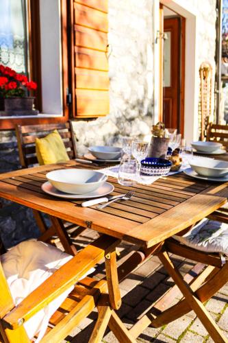a wooden table with plates and dishes on it at Da Bino - Vicino Pista Ciclabile in Valle di Cadore