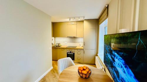 a kitchen with a table with a bowl of oranges on it at Apartamenti Pētera 28 in Ventspils
