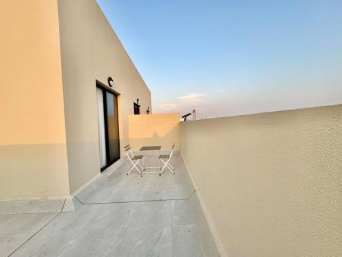 a white chair sitting on a floor next to a wall at Spacious unit with a terrace in Dubai