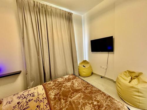 a room with a bed and a television in a room at Spacious unit with a terrace in Dubai