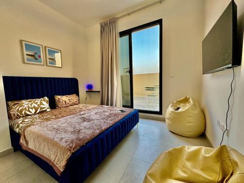 a bedroom with a bed and a large window at Spacious unit with a terrace in Dubai