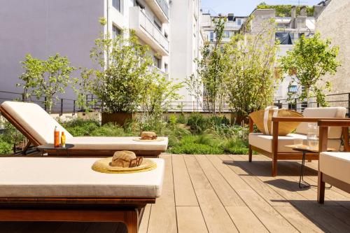 a rooftop patio with furniture and a garden at Belinda Hôtel & Spa in Paris