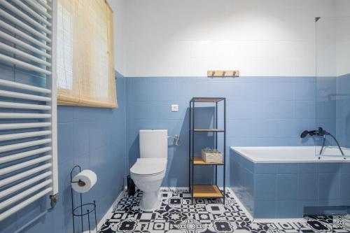 La salle de bains bleue est pourvue de toilettes et d'une baignoire. dans l'établissement Ostoja przy potoku- z tarasem oraz parkingiem- BestRooms, à Międzybrodzie Żywieckie