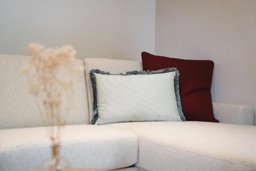 a white couch with a pillow on it at Alpenschlössl Boutique Appartements & Rooms in Neustift im Stubaital