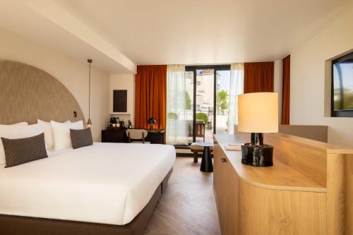 a bedroom with a bed and a desk with a lamp at Belinda Hôtel & Spa in Paris