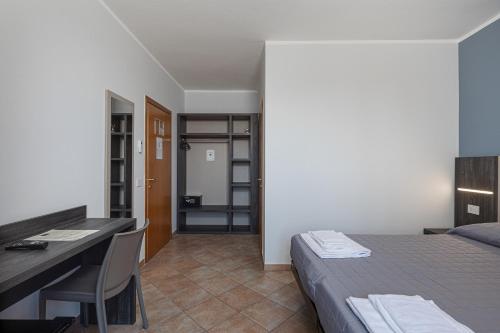 a bedroom with a bed and a desk and a deskablish at Urban Hotel in Cesena
